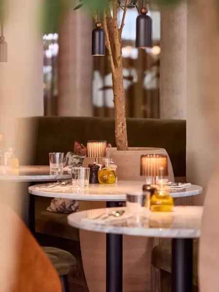 Les clients profitent d’une expérience culinaire sur la terrasse estivale des restaurants du Van der Valk Hotel Gand, dans une atmosphère chaleureuse et détendue.