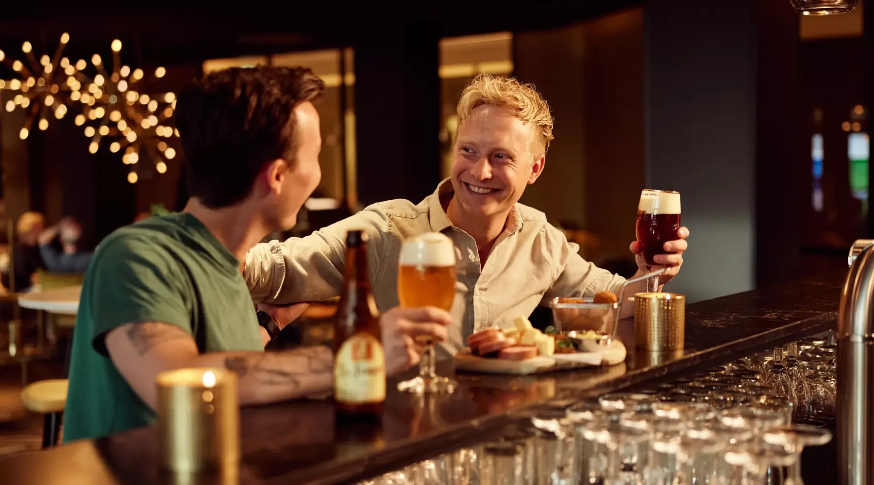 2 Freunde trinken ein Bier an der Bar des Hotels Breukelen.