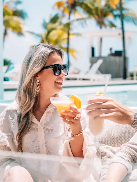Groep meiden op het strand met drankjes.