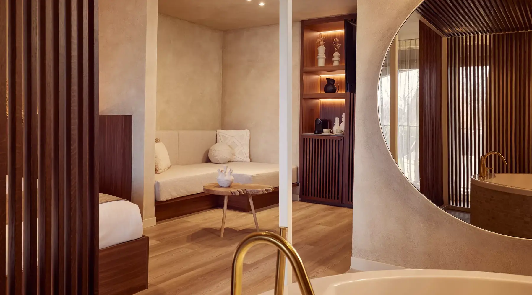 Luxury suite at Hotel Beveren, in warm beige and brown tones, with a king-size bed, sofa and bath.