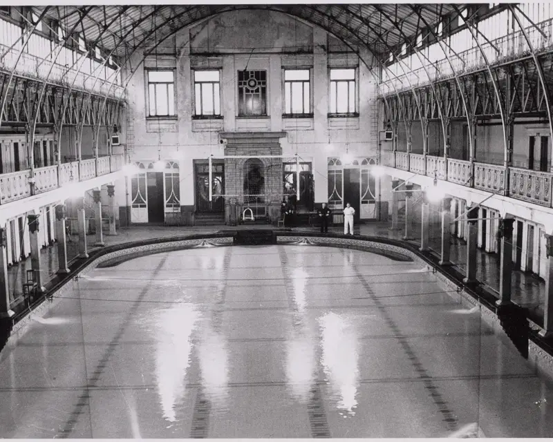 Het zwembad bij de opening is 1924 met prachtig metalen dak en houten kleedhokjes