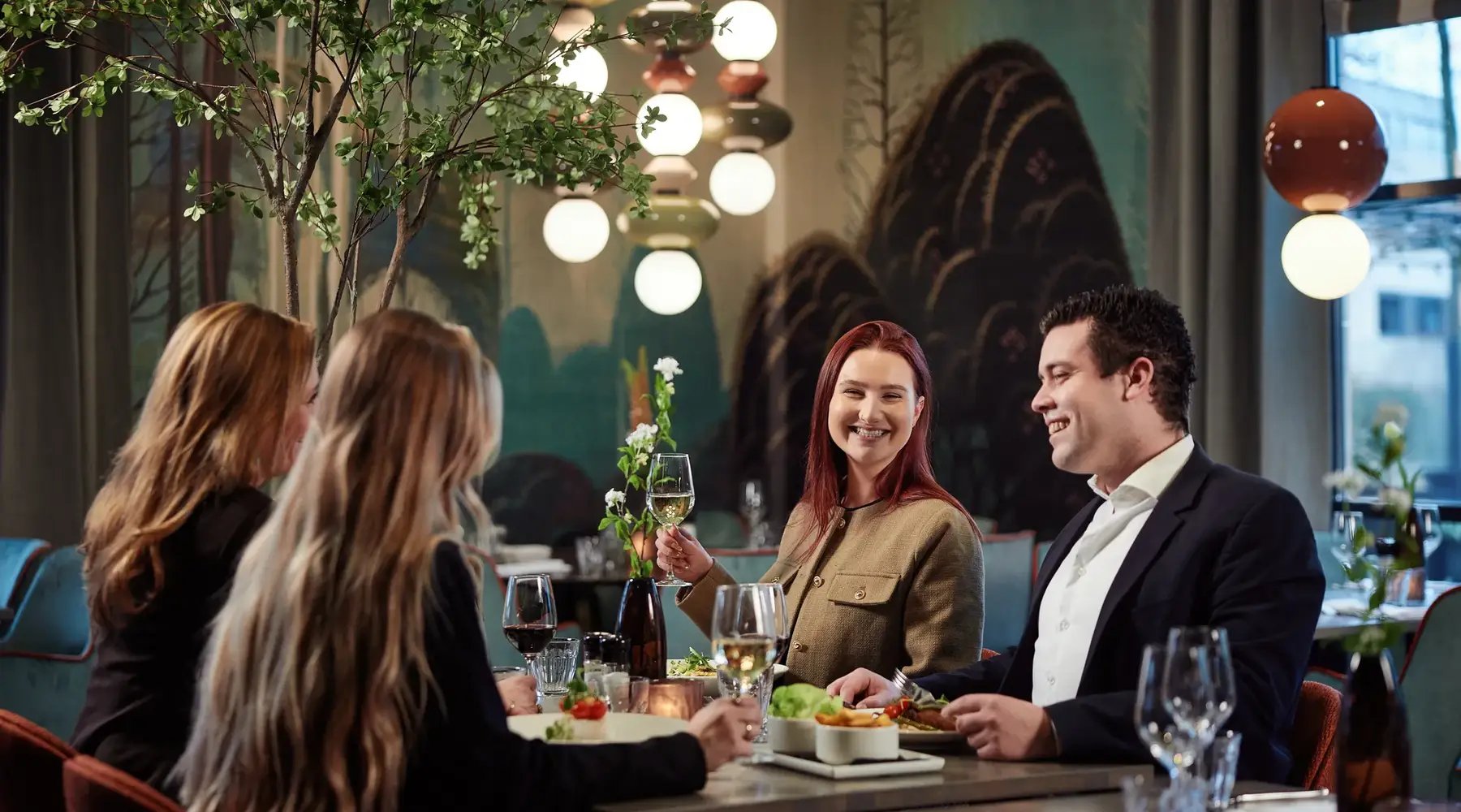 4 people at a table enjoying dinner with wine