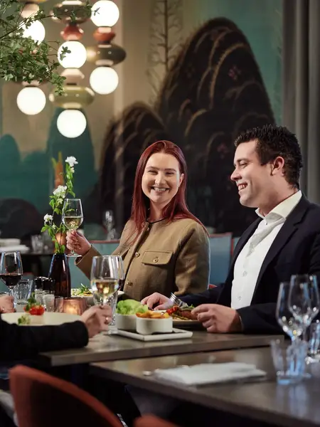 4 people at a table enjoying a dinner with wine