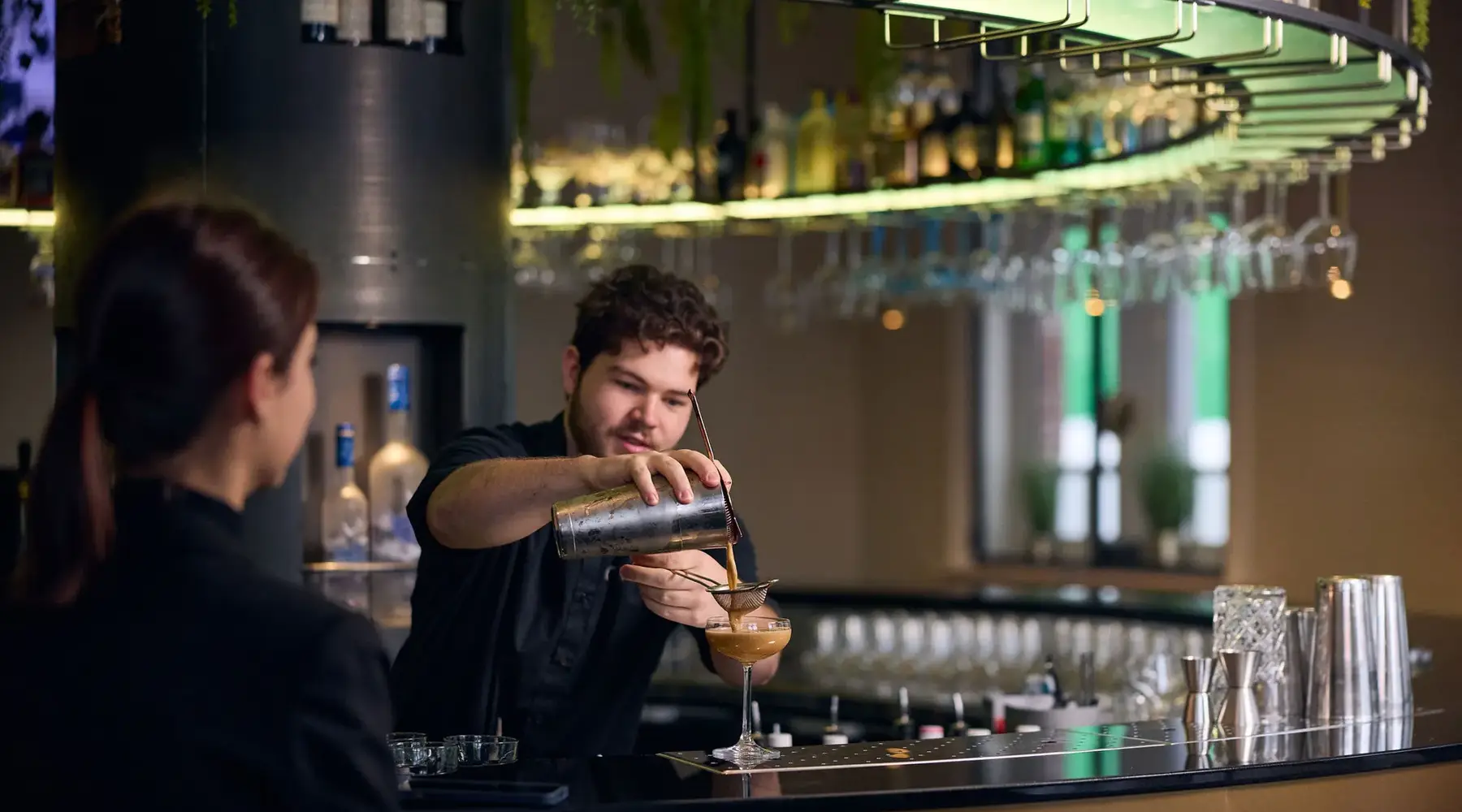 Barkeeper, der einen Cocktail einschenkt