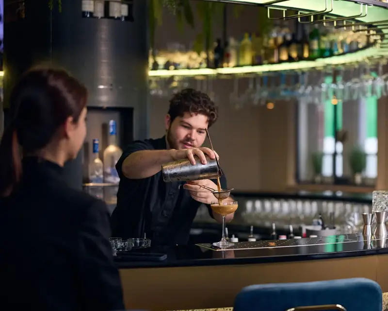 Barman van Bar Bernard die een cocktail uitschenkt