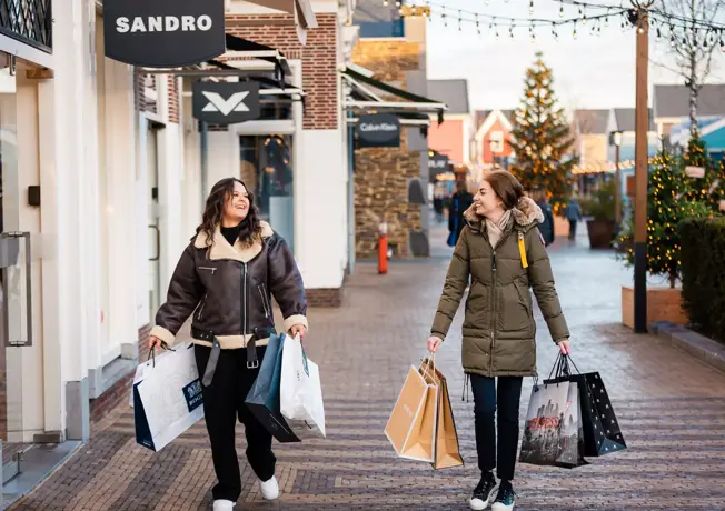 Shoppende vrouwen bij Batavia Stad