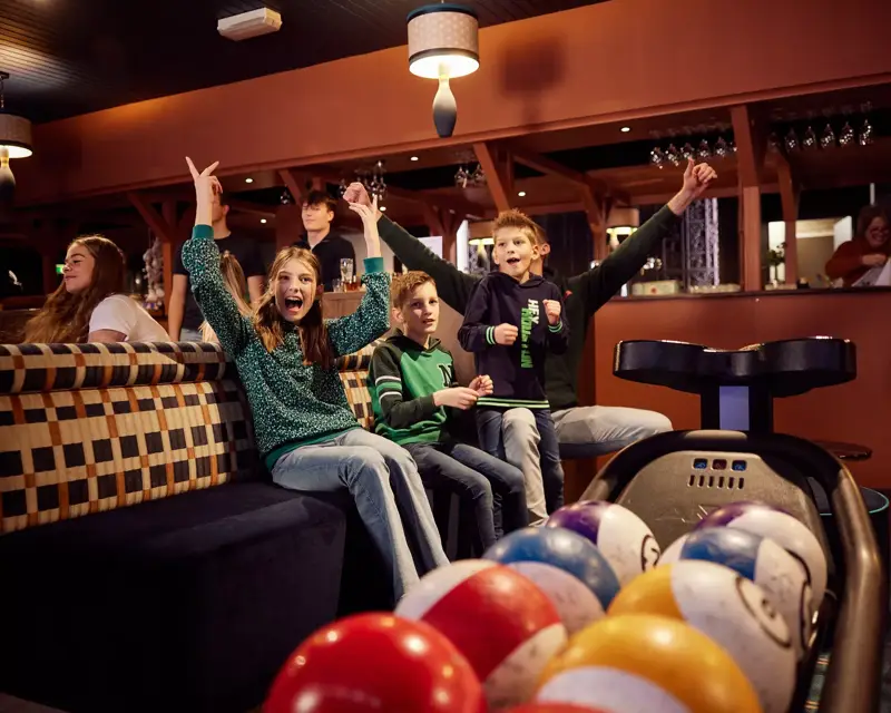 Jubelnde Kinder auf der Bowlingbahn