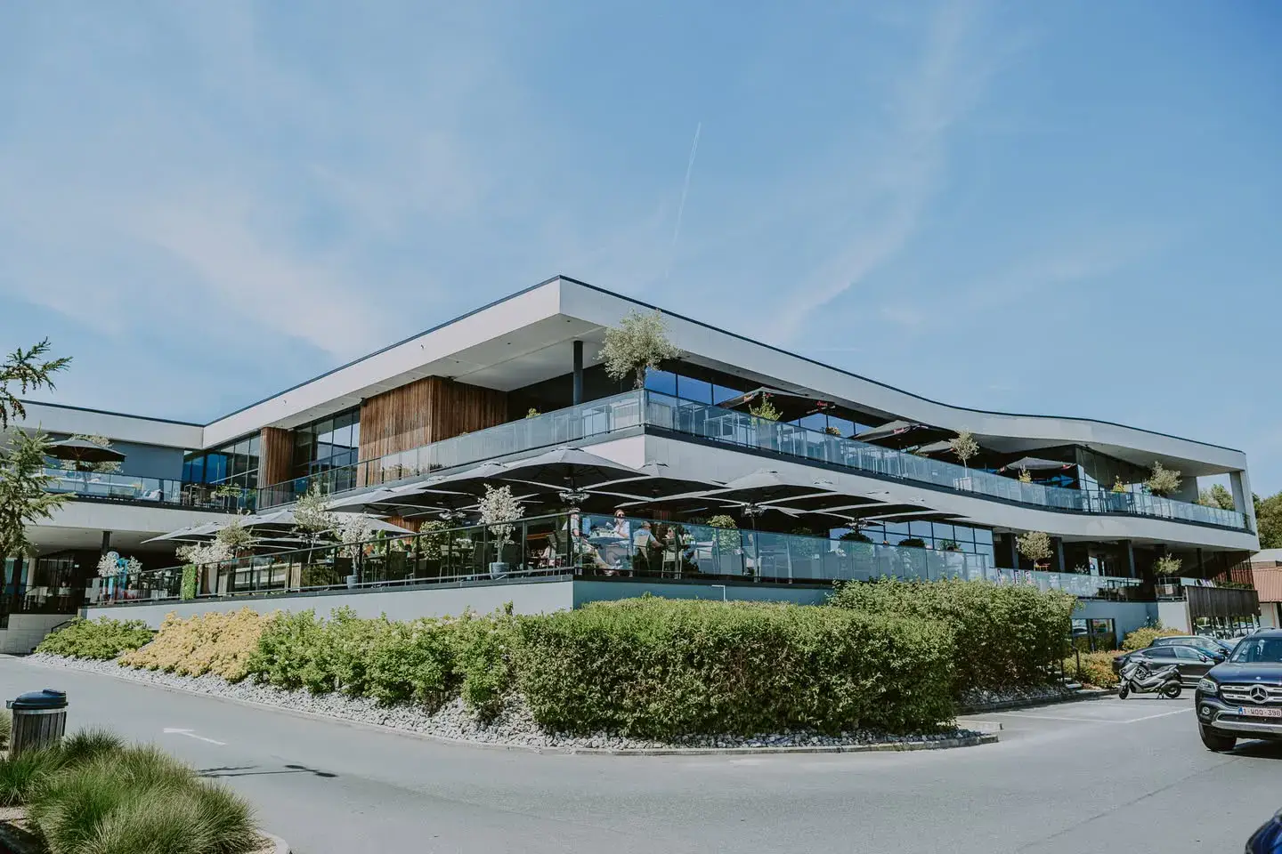 Exterior view of the Van der Valk Hotel Nivelles-Sud featuring its modern architecture and guest parking.