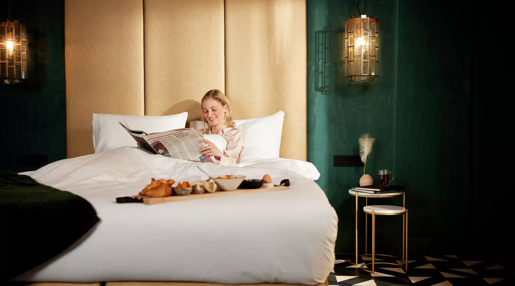 Woman enjoys the newspaper and breakfast in bed.