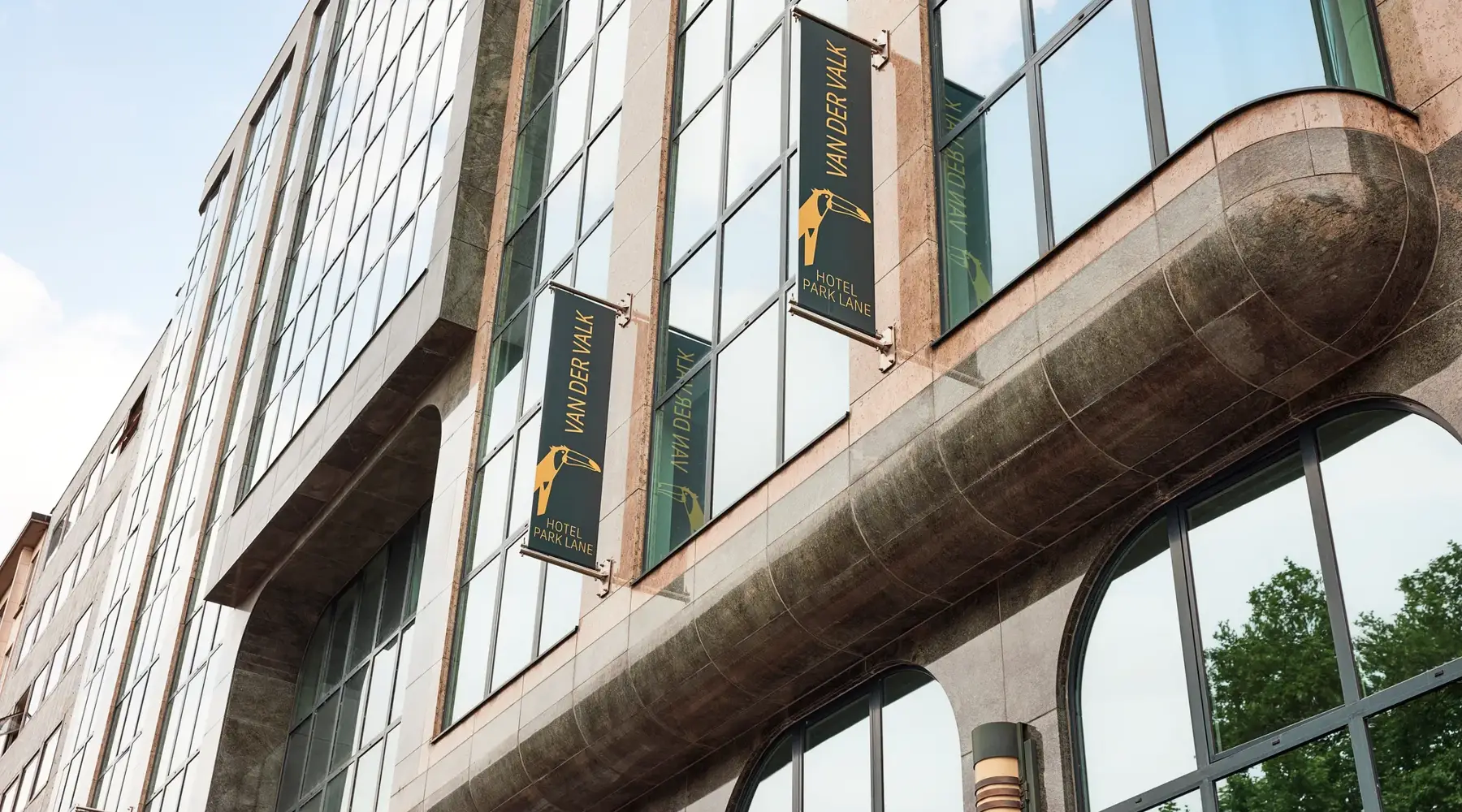 Hotel Park Lane Antwerpen van de buitenkant. Bruine stenen met groen/goude van der valk vlaggen.