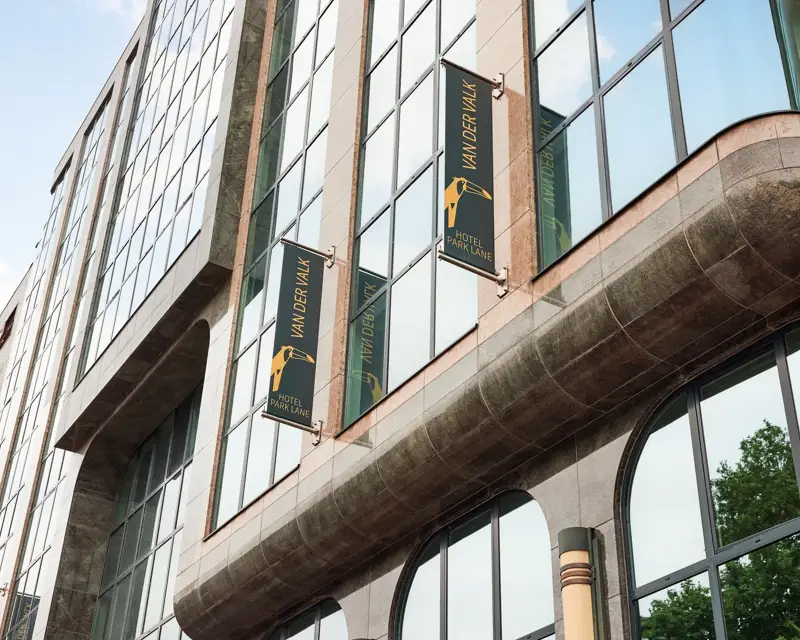 Hotel Park Lane Antwerpen van de buitenkant. Bruine stenen met groen/goude van der valk vlaggen.