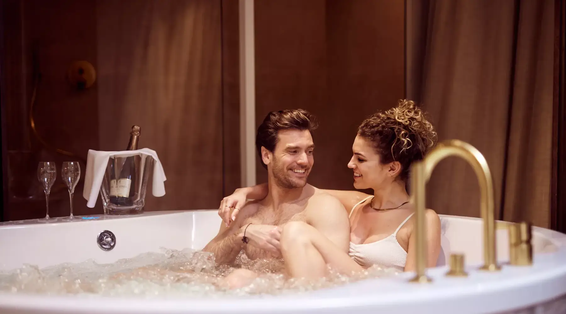 Een koppel zit samen in bubbelbad op een hotelkamer