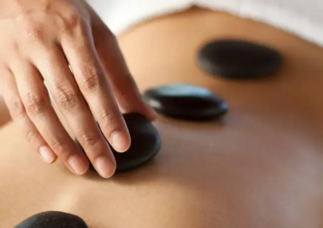Hot stone massage is a type of massage therapy that involves the use of smooth, heated stones. The massage therapist places the hot stones on specific points on the body and may also hold the stones while performing the massage. The heat from the stones helps to relax muscles and improve blood flow.