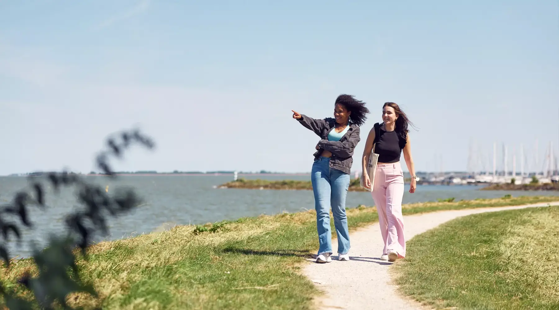 Two friends walking along the water