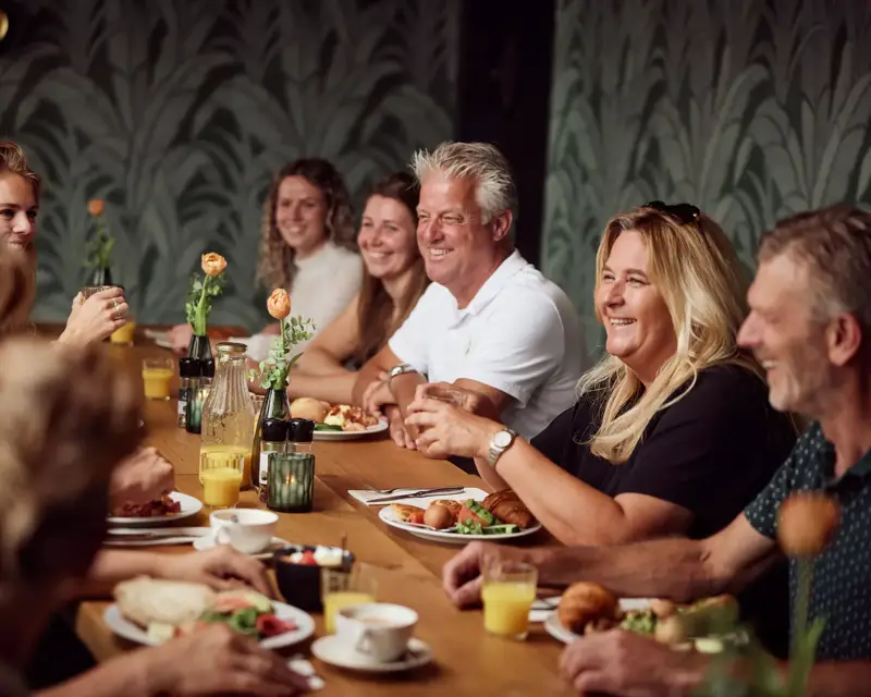 Een groep geniet van een maaltijd aan tafel