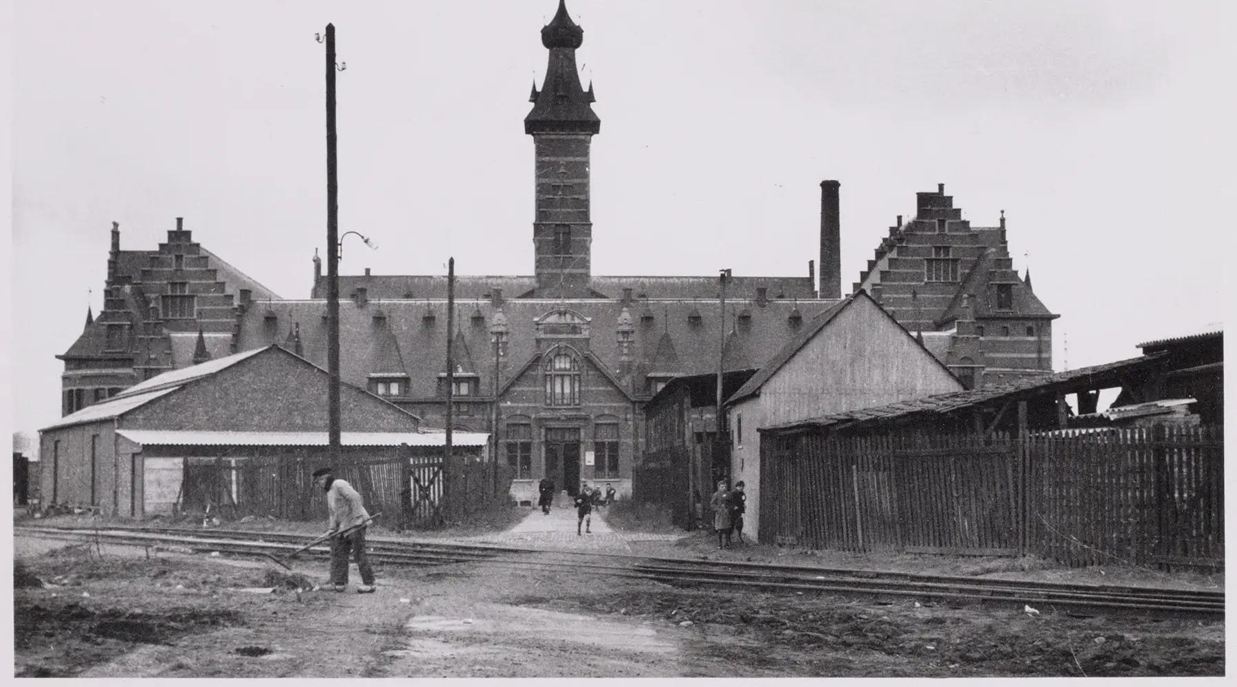 Het Mechelse badhuis in de beginjaren met koterij en een tramlijn voor het gebouw