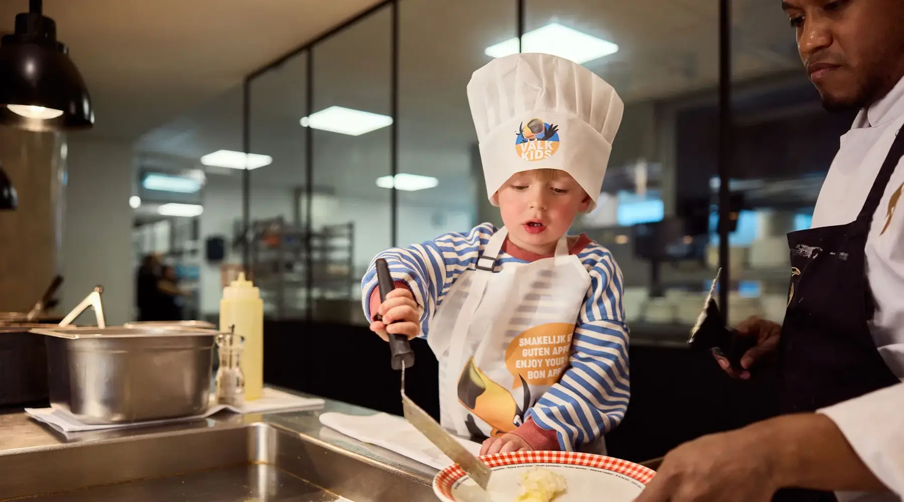 Kind maakt zelf zijn eitje met een chef tijdens het ontbijt in Van der Valk Hotel Gent