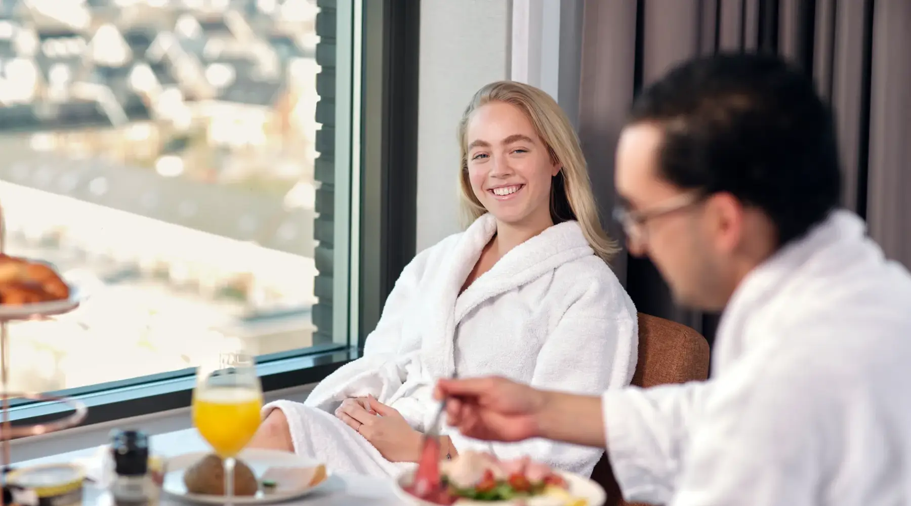 Ein Mann und eine Frau genießen ein Frühstück in ihren Hotelzimmern.