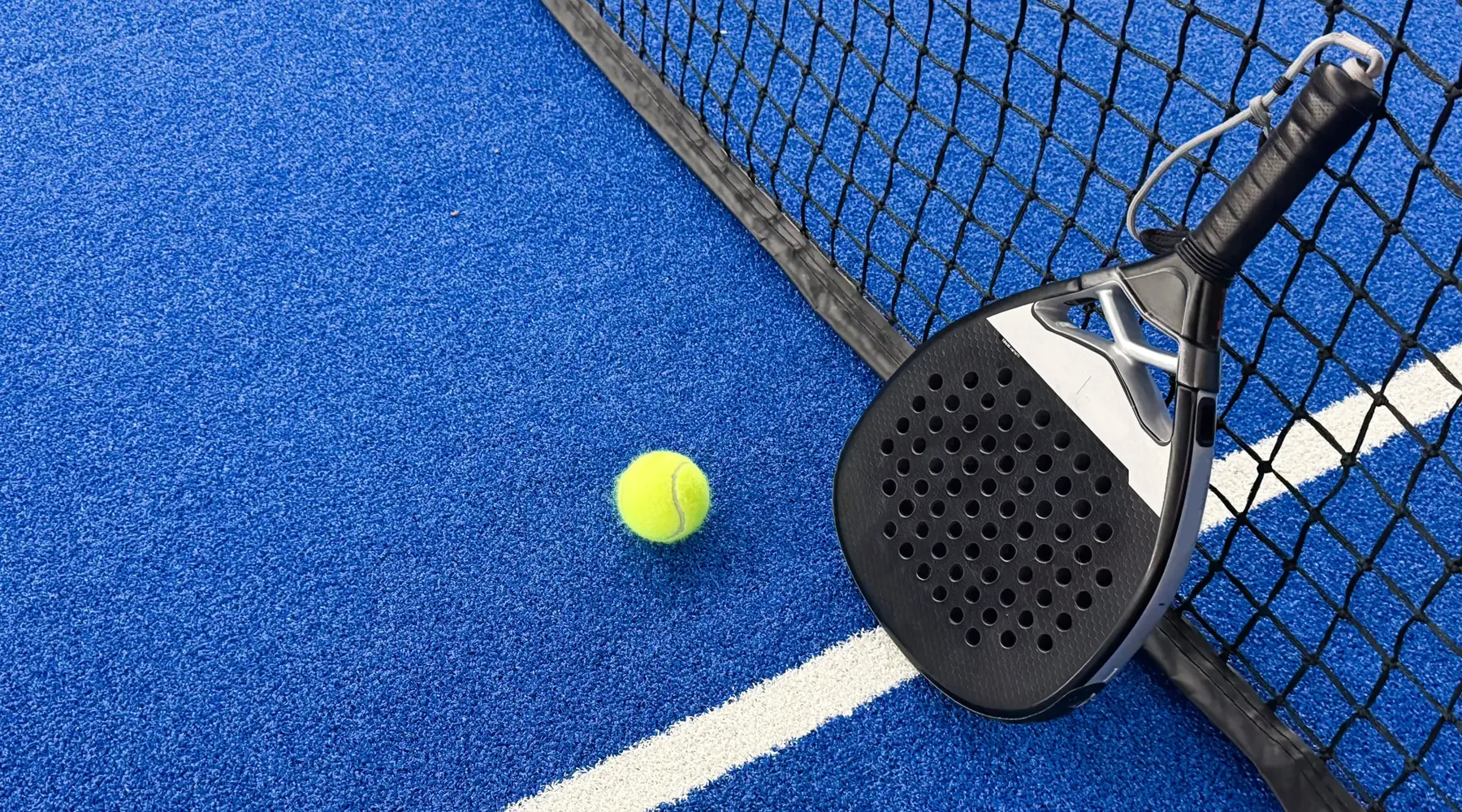 Pista de pádel con pala y pelota durante un viaje de pádel en grupo en Hotel Barcarola
