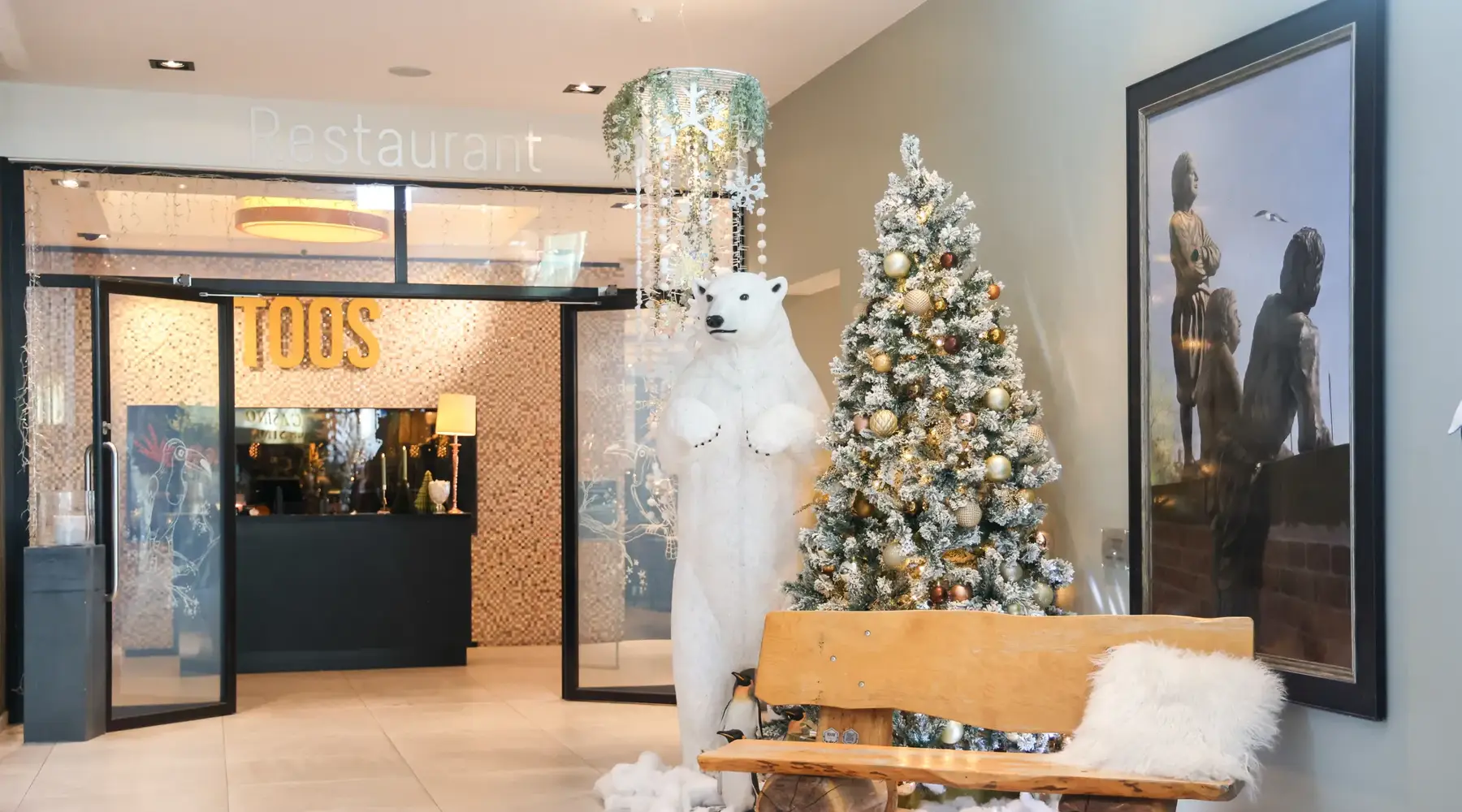 Feestelijk versierde entree van Toos Restaurant met kerstboom bij Van der Valk Hotel Hoorn.