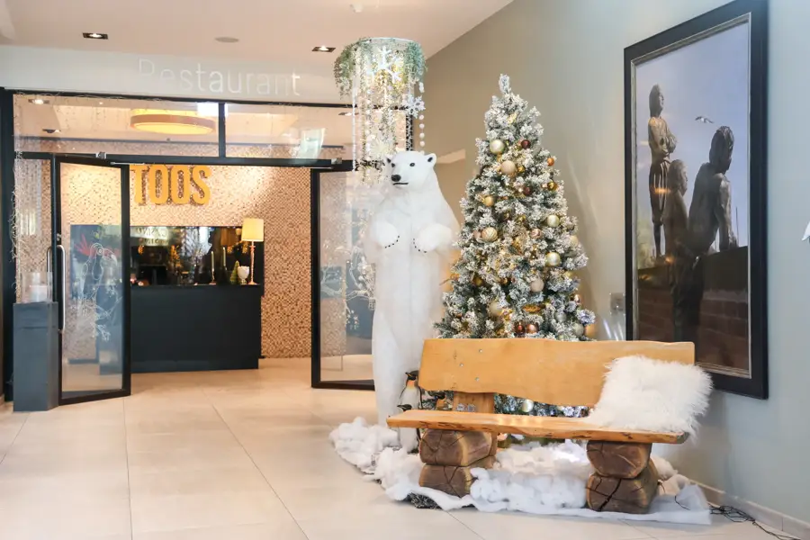 Entrée décorée pour les fêtes du restaurant Toos avec un sapin de Noël à l'hôtel Van der Valk à Hoorn.