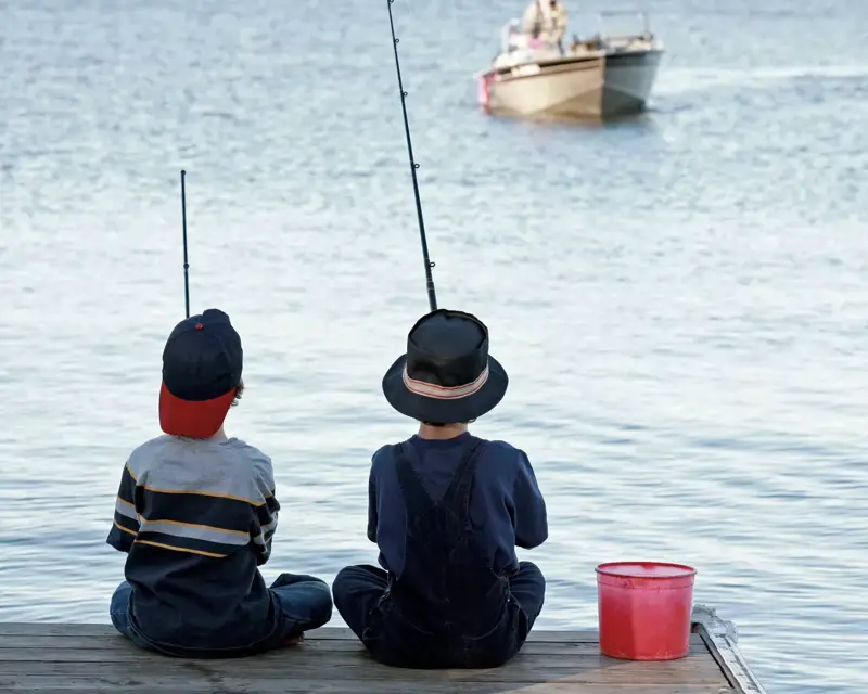 Jungen, die am See angeln.