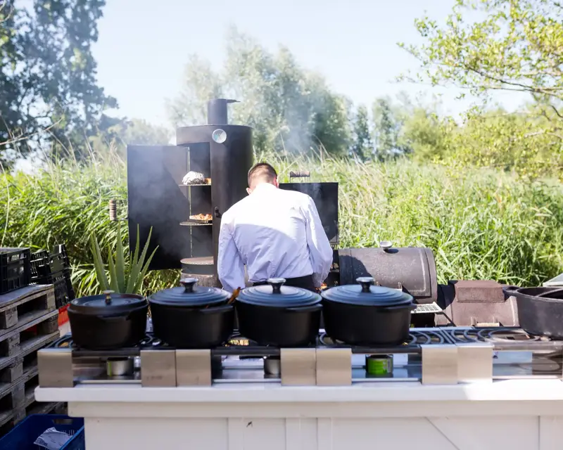 Een kok kookt op een barbecue in de tuin van Hotel Volendam