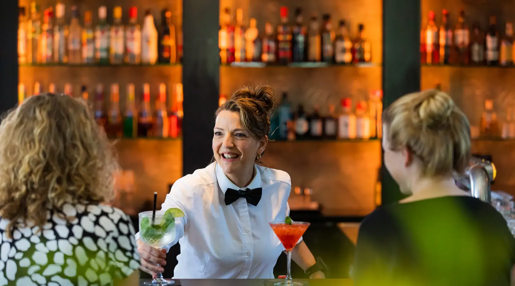 Serveerster die cocktails aan de gast bediend in OZZO Food & Drinks