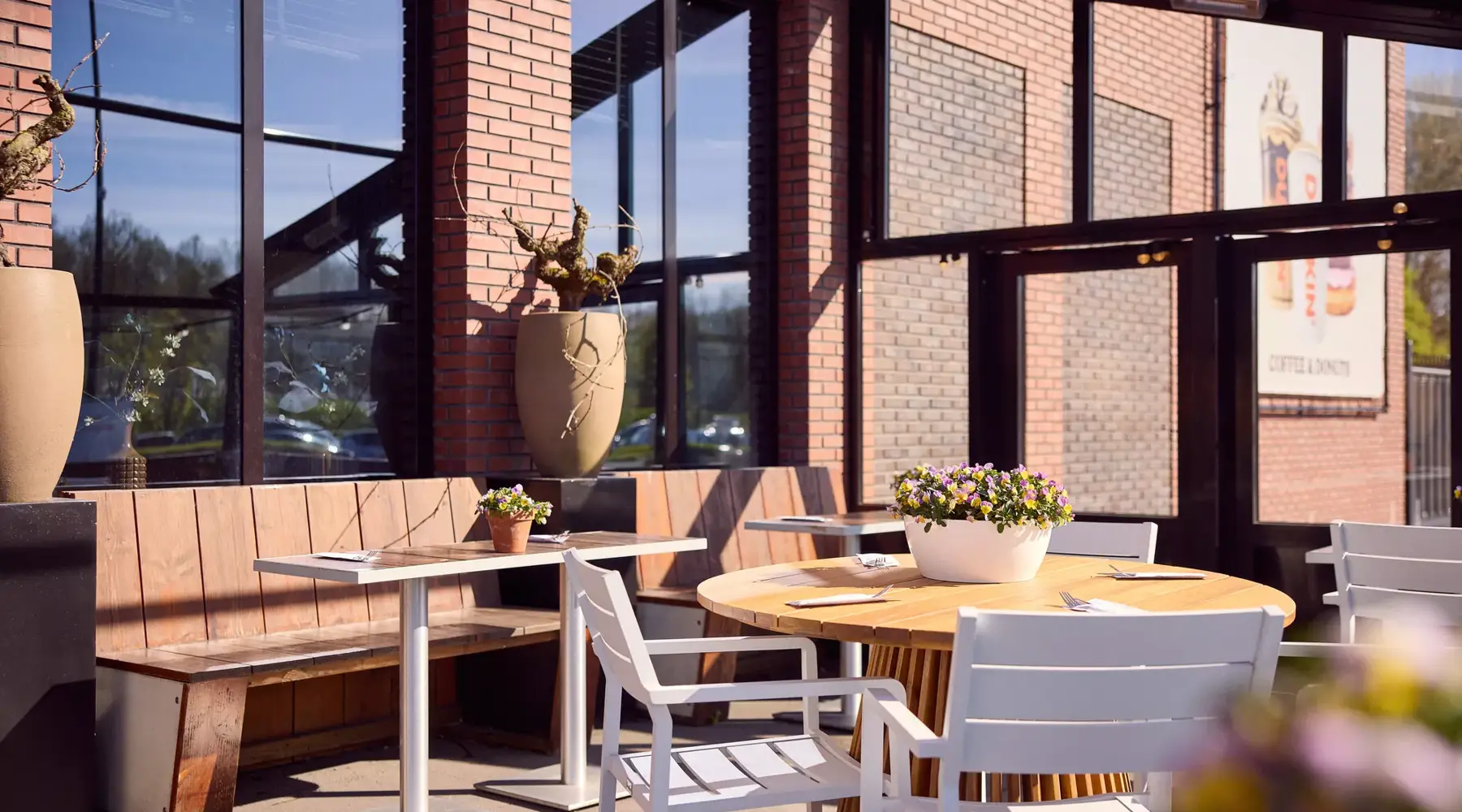 Terrasse ensoleillée avec tables et sièges à l'hôtel Van der Valk Hoorn.