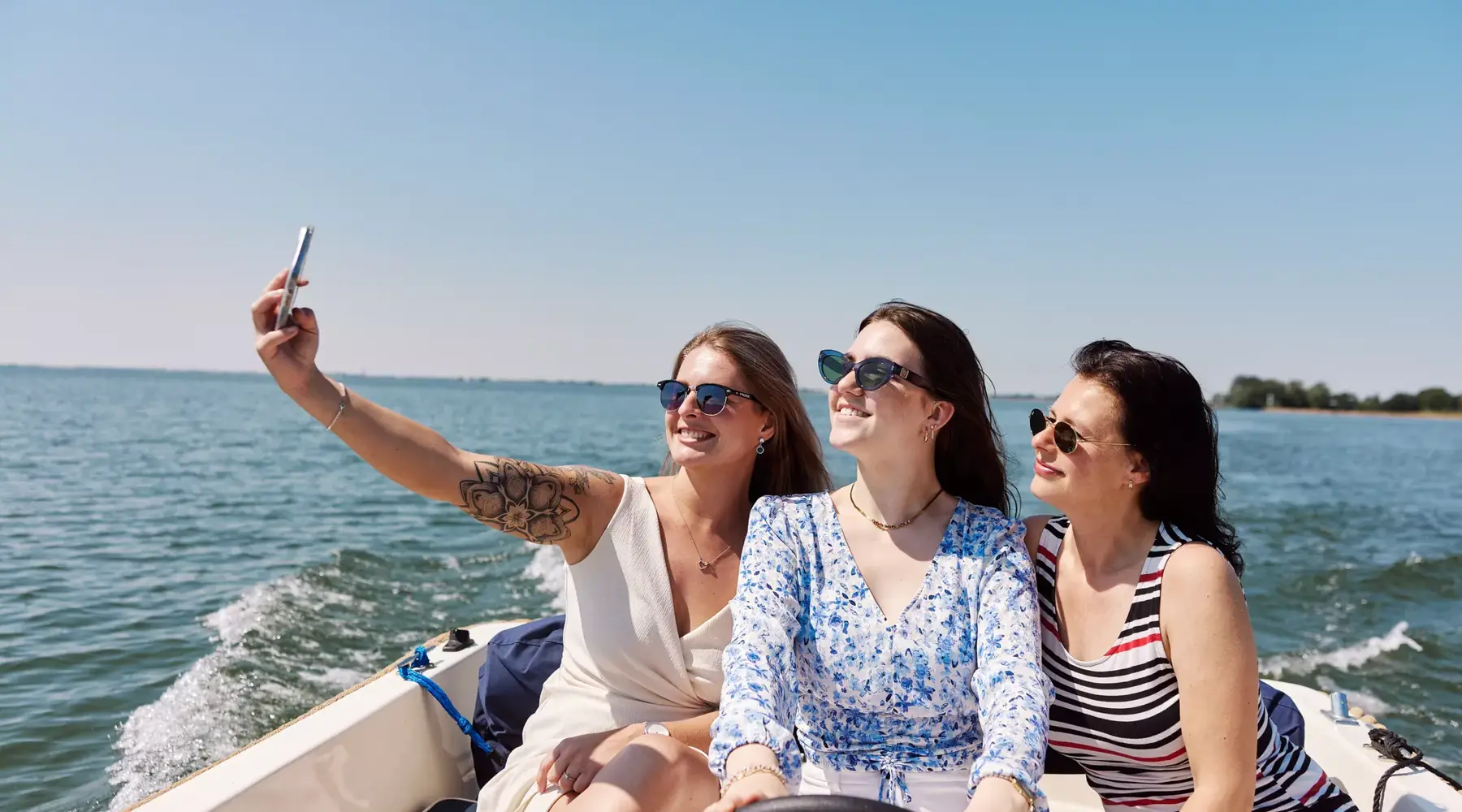 3 dames genieten van een boottocht in de zon