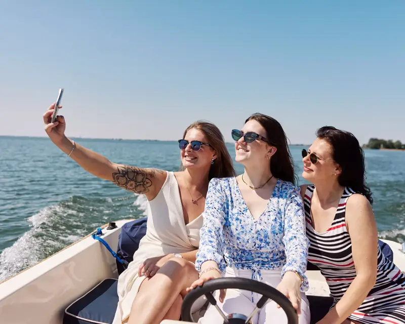 3 dames genieten van een boottocht in de zon