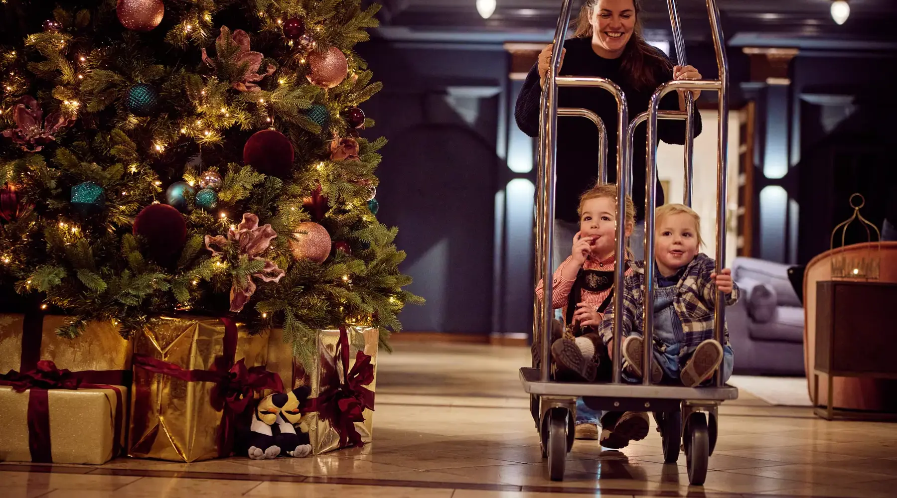 Weihnachtskulisse mit Kindern in Kofferwagen