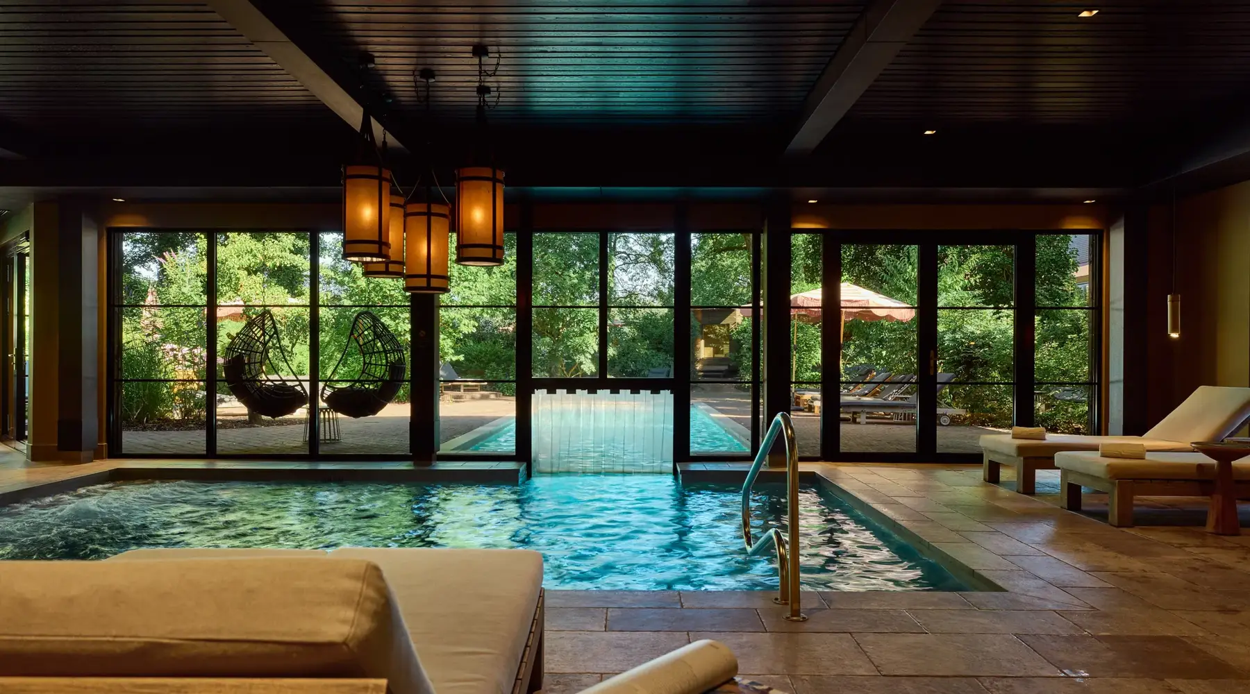 Wellnesstuin met binnenzwembad en relaxstoelen