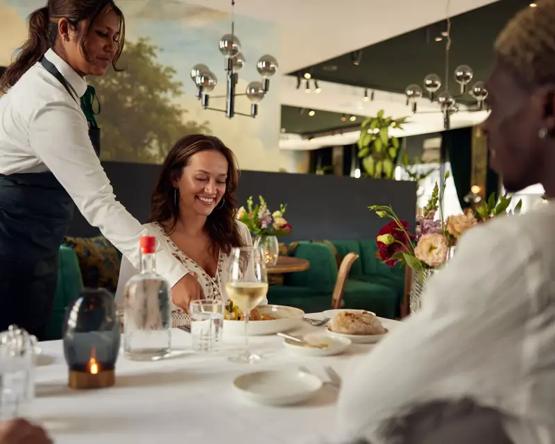 Bediening serveert gerecht Hotel Amsterdam Amstel