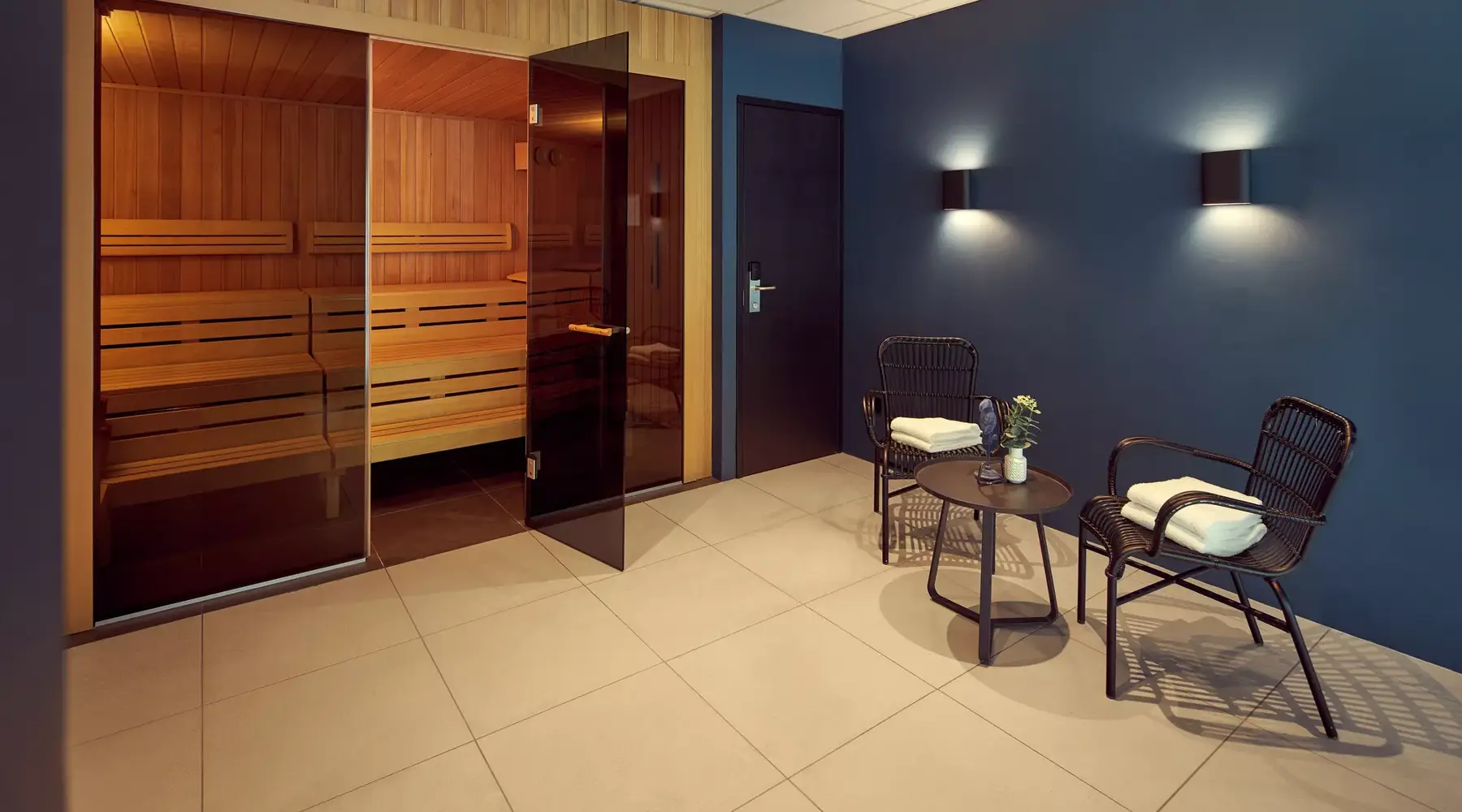 Sauna met daarbuiten klein tafeltje met 2 stoelen
