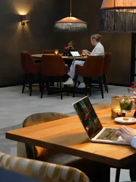 A man is working on a laptop in a hotel restaurant.