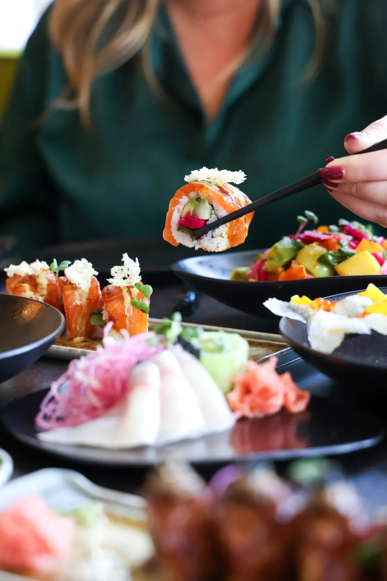 Frau nimmt ein Stück Sushi