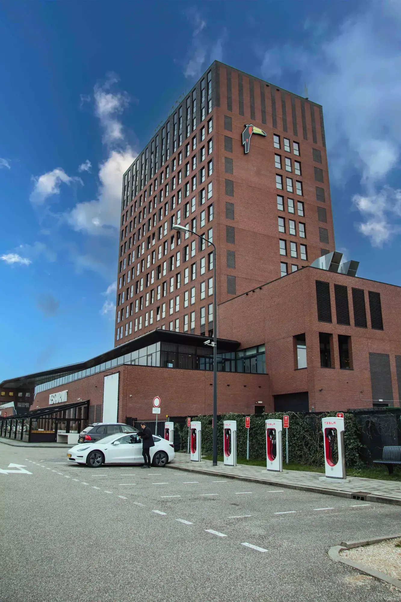 Seitenansicht des Hotels mit Tesla-Schnellladern