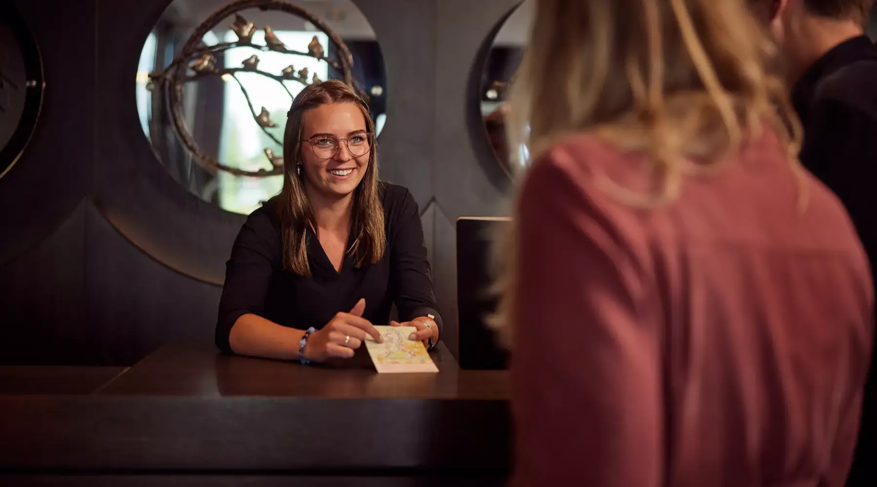 Vriendinnen checken in bij de receptie van een hotel