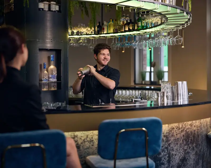Barman die een cocktail aan het mixen is