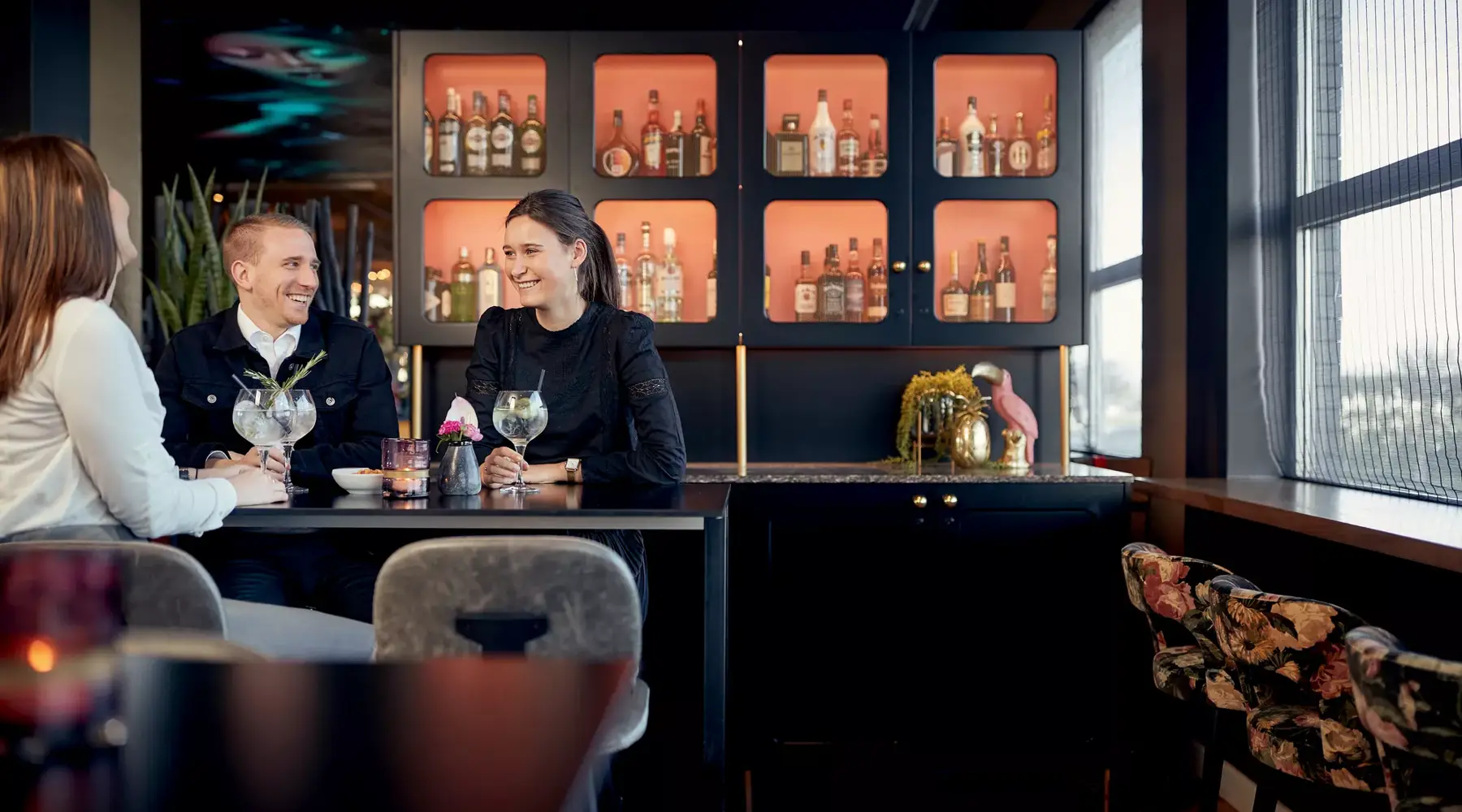 Lachende personen genieten van een drankje aan de bar in hotel brussels airport