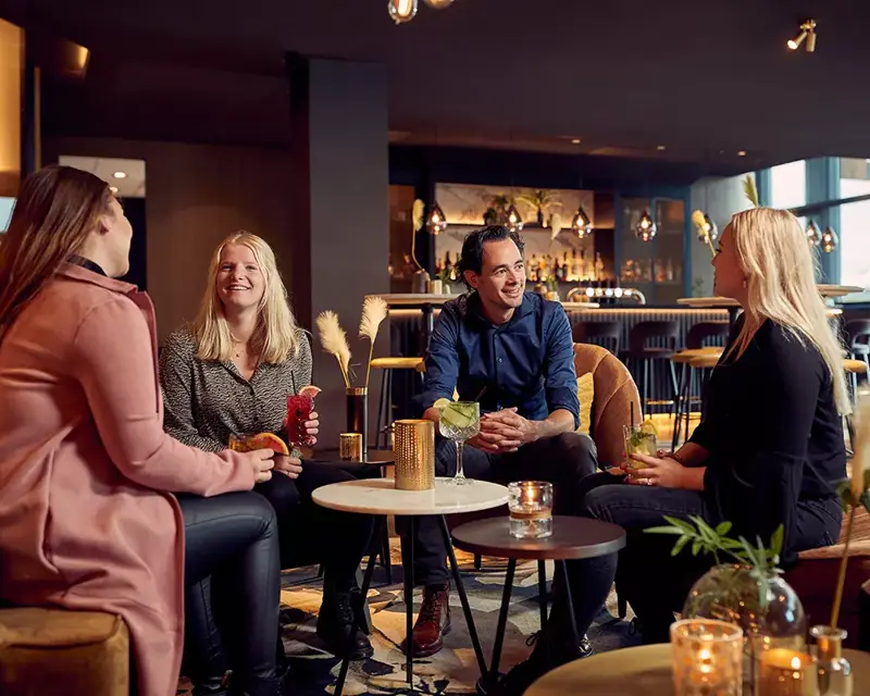 Guests are having a drink in the hotel bar of Hotel Breukelen
