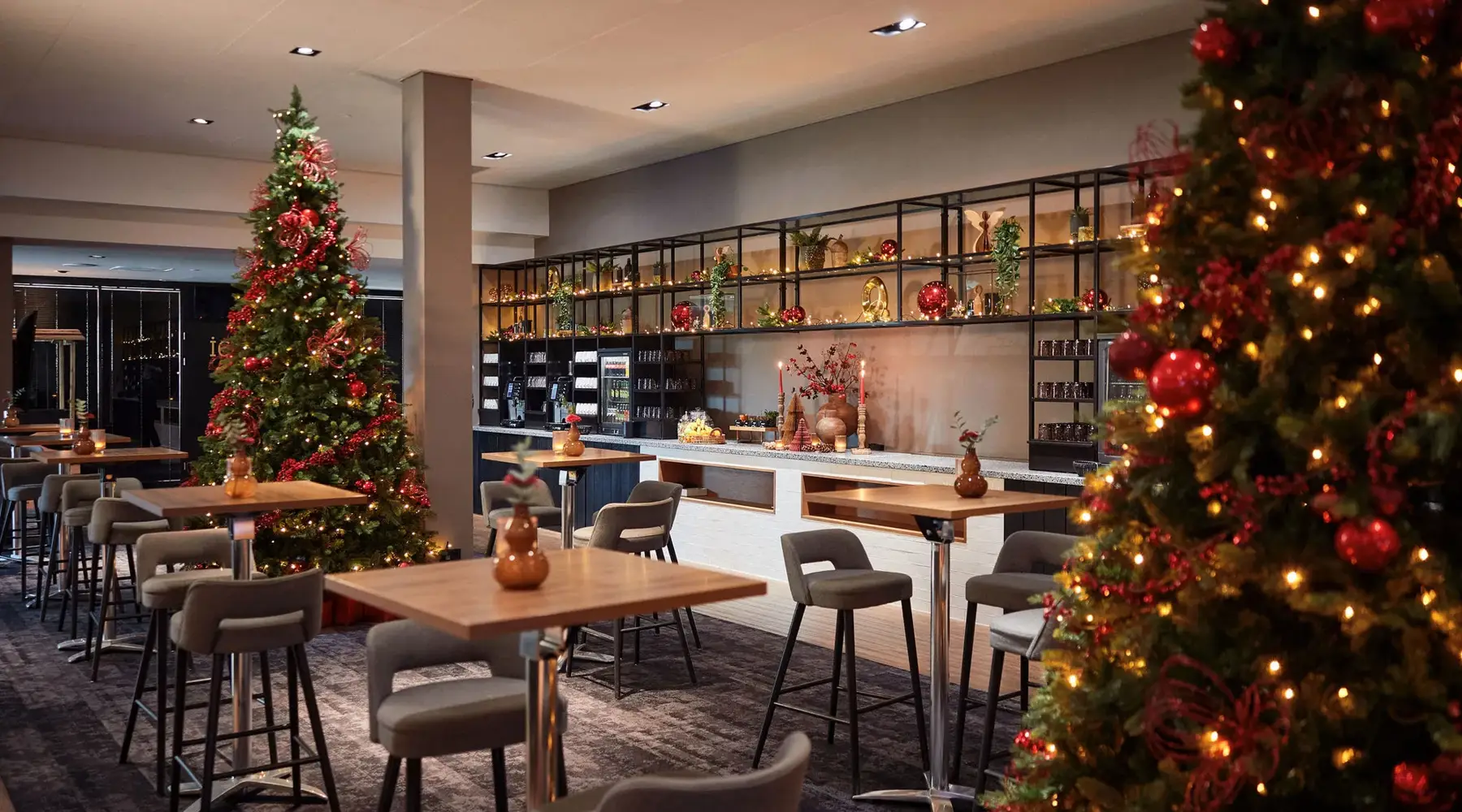 Fêtes d’entreprise au Van der Valk Hôtel Sassenheim – Leiden | Espace café avec sapins et décorations de Noël