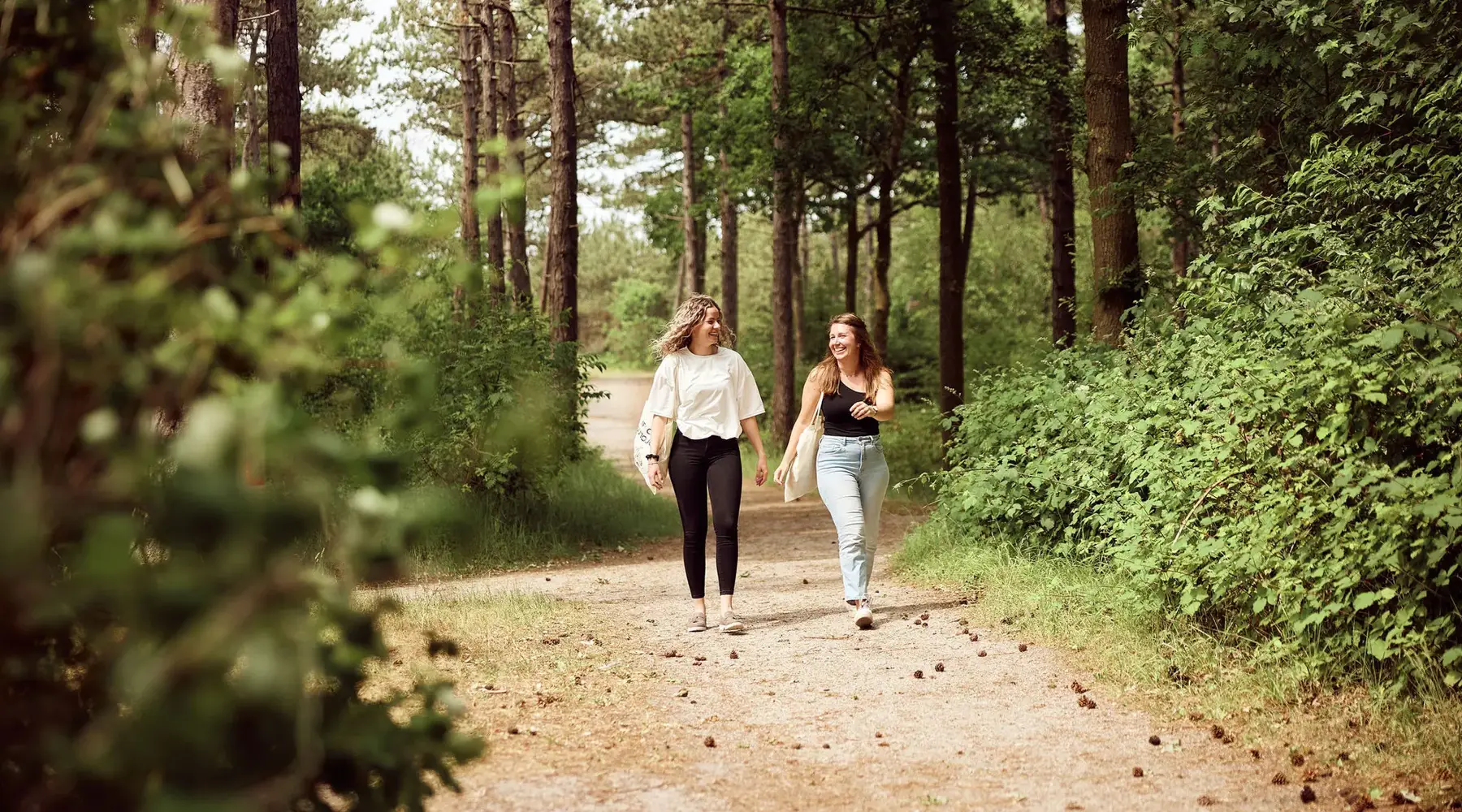 2 girlfriends walk through the woods