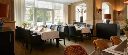 Spacious dining setup in Zaal de Witte, featuring long tables suitable for a large party or a private dinner.