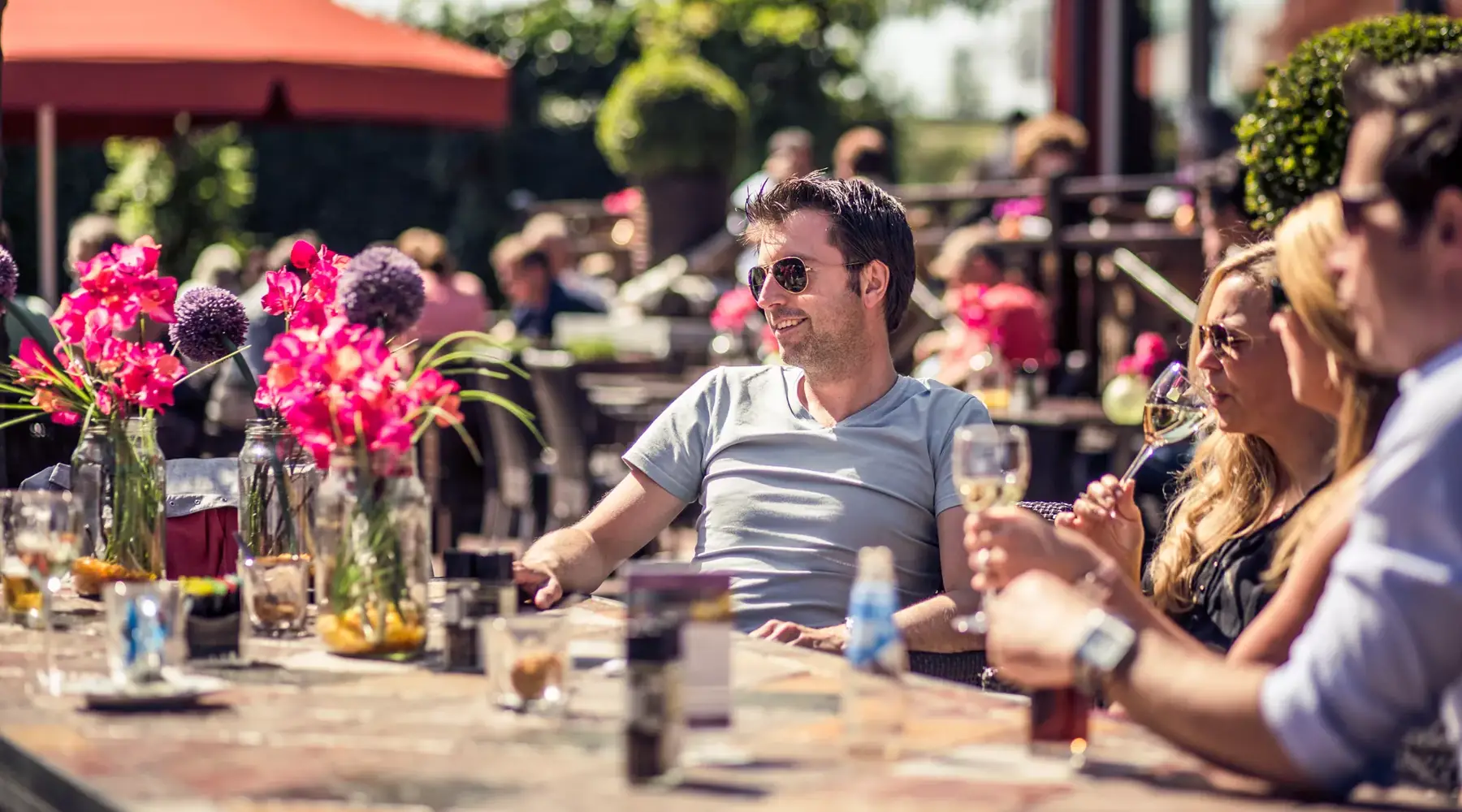 Mann mit Gesellschaft auf der Terrasse in der Sonne
