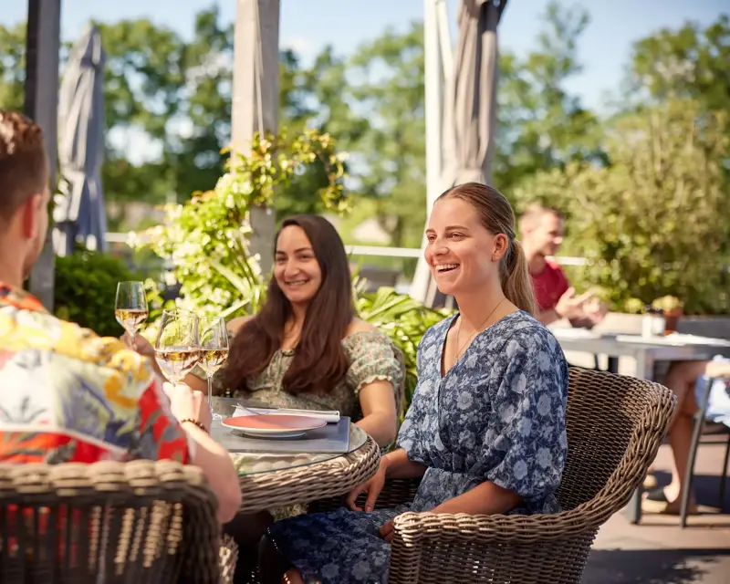 Freunde sitzen auf einer Hotelterrasse.