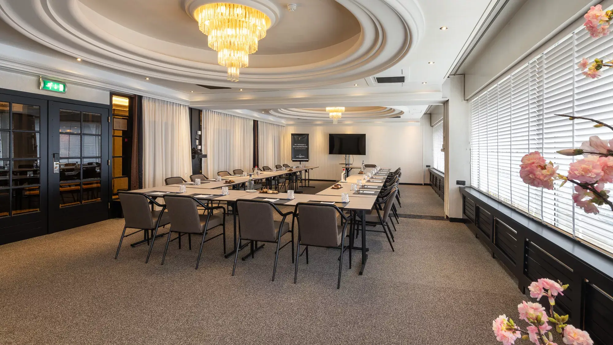 De lichte Strausszaal ingericht in een U-opstelling, voorzien van comfortabele stoelen en een modern afgewerkt plafond.