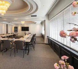 De lichte Strausszaal ingericht in een U-opstelling, voorzien van comfortabele stoelen en een modern afgewerkt plafond.