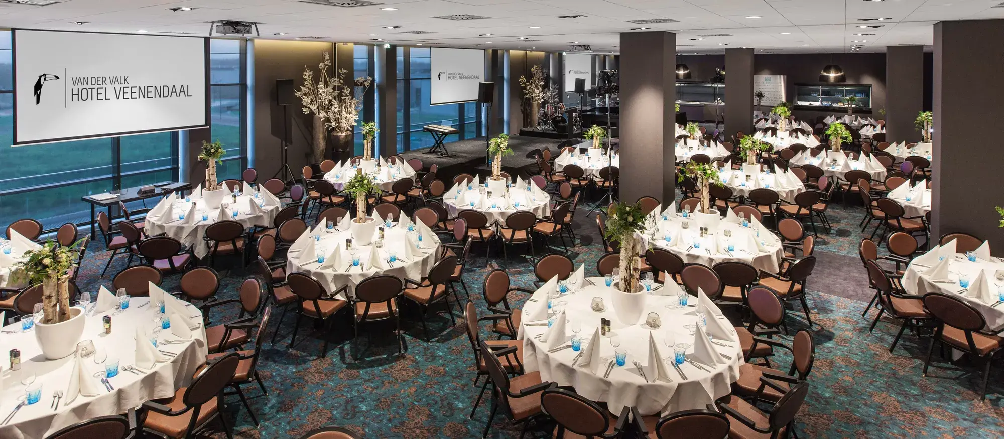 Feestelijke opstelling van tafels en stoelen in een zaal